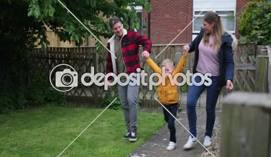 Annem ve babam onların küçük çocuk Markete alışverişe olduktan sonra kendi bahçesine doğru yürürken kollarını tarafından havada sallanan.