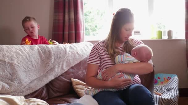 Μητέρα Λικνίζοντας Νεογέννητο Μωρό Της Για Ύπνο Ενώ Παλαιότερο Γιο — Αρχείο Βίντεο