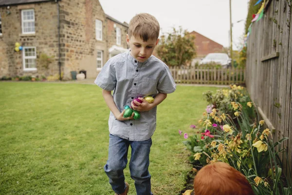 Niño Sosteniendo Sus Brazos Llenos Huevos Pascua Chocolate Están Buscando —  Fotos de Stock