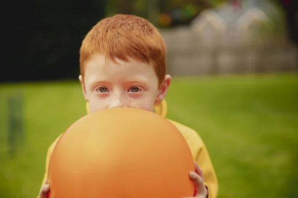 Rapazinho Segurar Balão Laranja Cara Ele Está Olhando Para Câmera — Fotografia de Stock