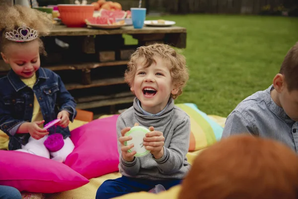 Opgewonden Kleine Jongen Zit Buiten Met Zijn Vrienden Hem Heen — Stockfoto