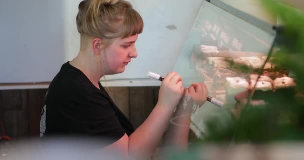 Woman Writing Prices Cakes Cookies Glass Window Front Them — Stock Video