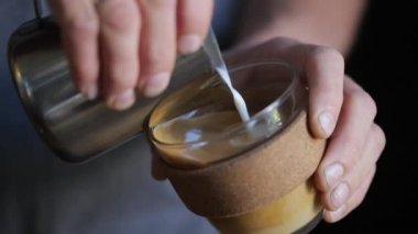 Sıcak süt yavaş hareket, barista kahve içine dökülür varlık ile süt desenler oluşturma.