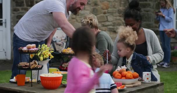 Groep Van Ouders Kinderen Buiten Zitten Genieten Van Een Tuinfeest — Stockvideo