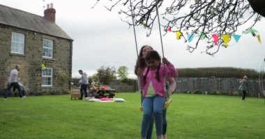 Küçük bir kız iken onu annesine yardımcı olur ve onu iter bir salıncak üzerinde dışında oynarken. O eğleniyor ve kendini zevk. 