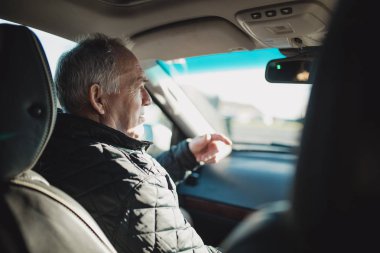 Komuta sizde çerçevede görülemez sürücü konuşurken bir arabasının yolcu koltuğunda oturuyor. 