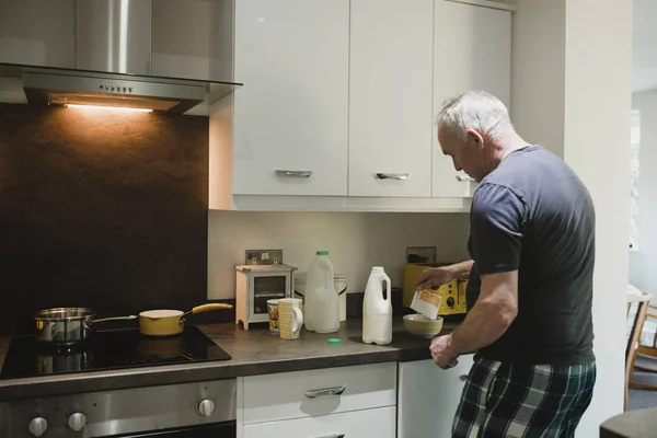 Homem Sênior Está Fazendo Porrdige Instantâneo Cozinha Sua Casa — Fotografia de Stock