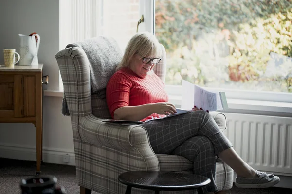 Una Mujer Madura Está Sentada Sillón Sala Estar Casa Leyendo — Foto de Stock