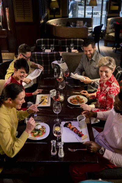 Pequeño Grupo Amigos Disfrutando Una Comida Restaurante Están Sentados Una —  Fotos de Stock