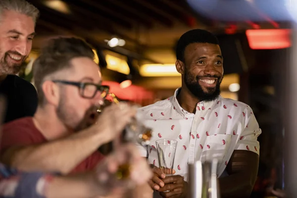 バーで一緒にビールを楽しむ大人の男性の友人3人 — ストック写真