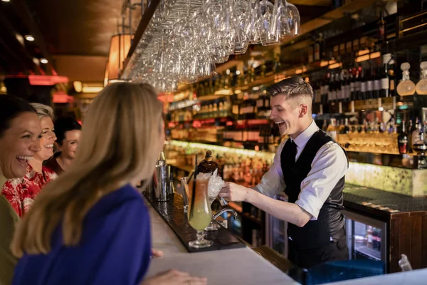 Jovem Barman Fazendo Coquetel Para Pequeno Grupo Mulheres Desfrutando Noite — Fotografia de Stock