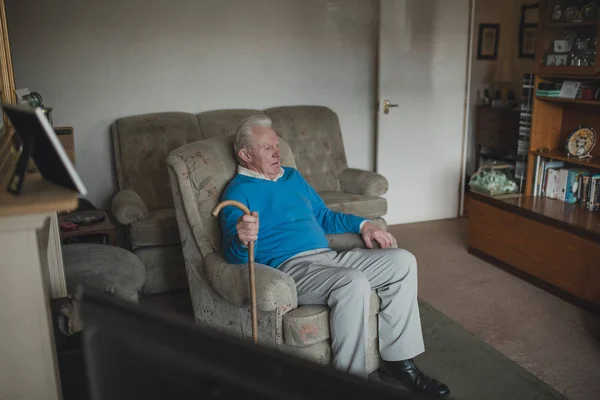 Senior Man Zit Zijn Woonkamer Thuis Met Een Wandelstok — Stockfoto