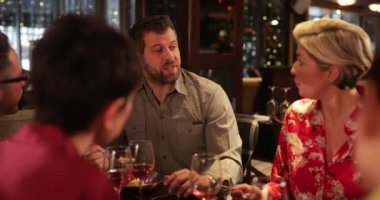 Laf olsun diye orta bir yetişkin adam omuz görünümü üzerinde. Bir restoran ve onun ortağı ve başka bir çift ile bir yemek keyfi o.