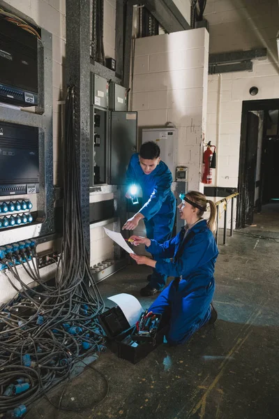Eletricistas fixando uma placa de interruptor — Fotografia de Stock