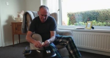 Üst düzey diyabetik adam evde onun kan şekeri seviyesini kontrol ediyor. 