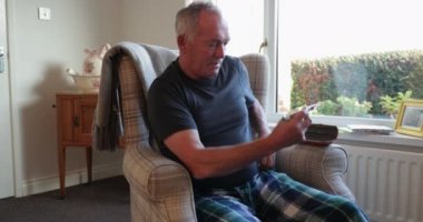 Diyabetli yaşlı adam evde karnına insülin enjekte ediyor..