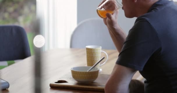 Senior Mannen Njuter Frukost Ensam Hemma Och Dricker Ett Glas — Stockvideo