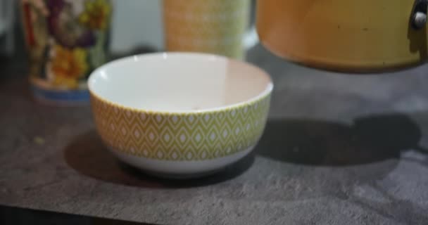 Gros plan d'un aîné versant sa bouillie dans un bol .