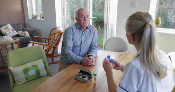 Медсестра Навещает Дому Старшего Диабетика Обсуждают Лечение Дал Образец Мочи — стоковое видео