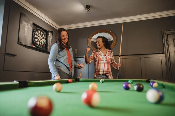 Konkurrenskraftiga vänner som spelar pool — Stockfoto