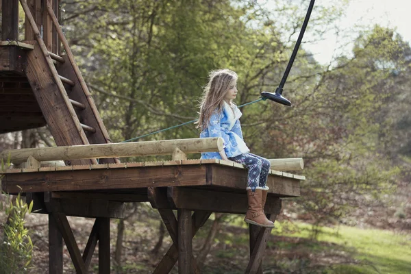 Маленька дівчинка сидить на гойдалці — стокове фото
