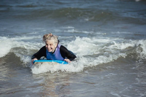 Donna matura Bodyboarding in mare — Foto Stock