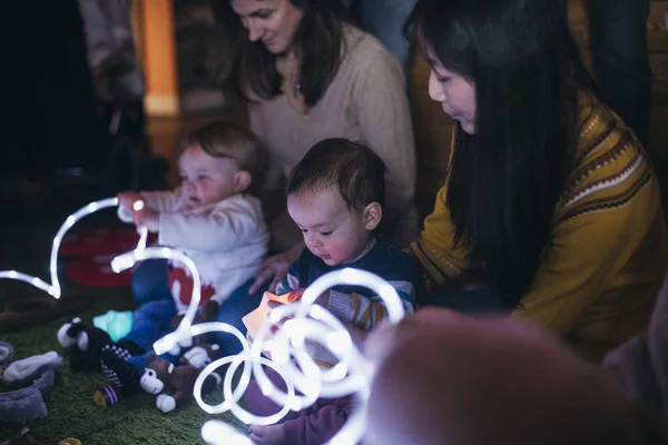 Diversão com luzes no grupo do bebê — Fotografia de Stock