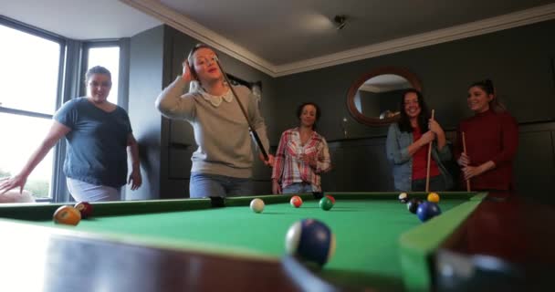 一小群朋友在家里的游戏室里玩八个球池 一个年轻的女性成人正在排队的提示球 以采取她的镜头 — 图库视频影像