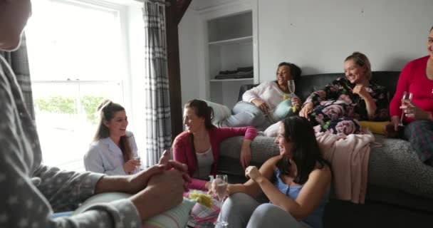 在一群女性朋友的肩上 她们穿着睡衣坐在卧室里 他们在一起聊天和玩乐 — 图库视频影像