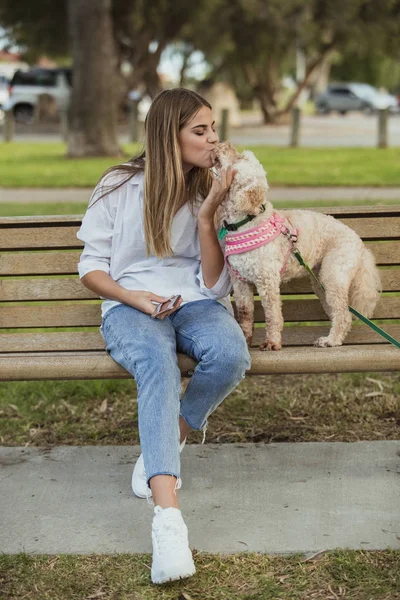 Adolescente chica besos su cachorro en el parque —  Fotos de Stock