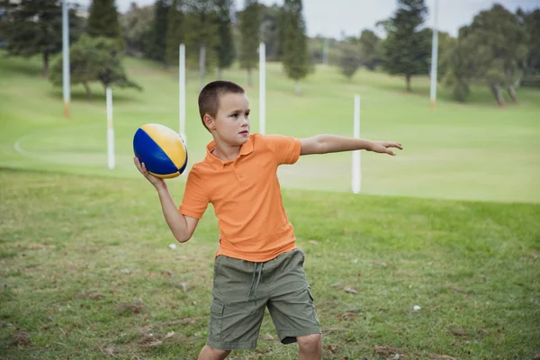 Мальчик играет в регби — стоковое фото