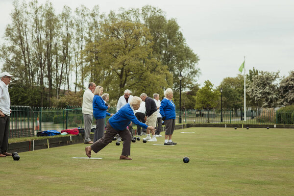 Senior Woman Bowling on Grass
