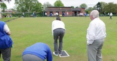 Çim bowling oyununda onun atış alarak üst düzey bir adamın bir arka görüş fotoğrafı.