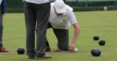 Üst sınıftan bir adamın galibiyet kasesi arasındaki mesafeyi ölçtüğü bir ön görüntü..