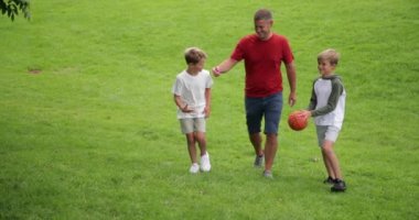 Arka bahçede bir basketbol topuyla oynayan bir aile fotoğrafı..