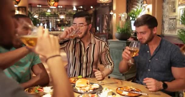 一緒に食事でお祝いのトーストを持っている男性の友人のグループ — ストック動画