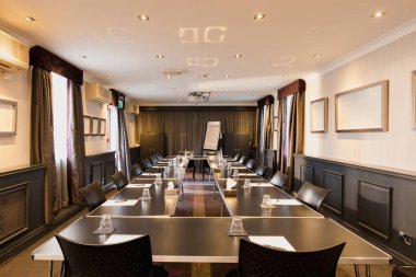 Her masada kağıt ve gözlüklerle bir iş görüşmesi için hazırlanmış büyük bir oda fotoğrafı..