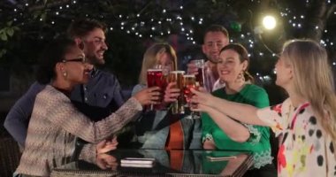 Farklı arkadaşlardan oluşan bir grup dışarıda bir bar / restoranda şampanya içerken, kutlama yaparken ve birlikte eğlenirken..