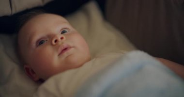 Sevimli bir çocuğun beşiğinde huzur içinde yatarken, huzurlu yüz ifadesini yakaladığı yakın plan bir fotoğraf..