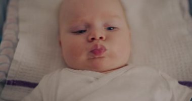 Yeni doğmuş bir bebeğin portresi. Değişim yastığında yatıyor. Ebeveynlik temaları için uygun sakin ve barışçıl bir ifade.