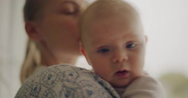 Annesinin omzunda dinlenen bir çocuğun samimi bir görüntüsü. Samimi ebeveynlik anları yakalıyor.