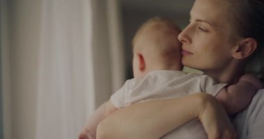 Bir annenin yeni doğmuş bebeğini kucakladığı ve pencereden dışarı baktığı o dokunaklı an. İkisi de bu anın tadını çıkarıyor. Bebek annesine sarılıyor..