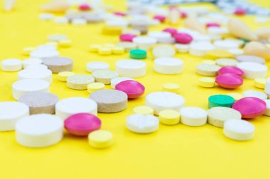 Çeşitli ilaç tıp hap, tablet ve kapsüller sarı arka plan üzerinde