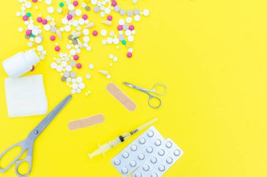 Çeşitli ilaç tıp hap, tablet ve kapsüller sarı arka plan üzerinde