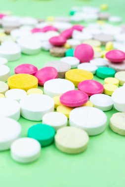 Çeşitli ilaç tıp hap, tablet ve kapsüller yeşil arka plan üzerinde