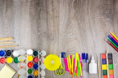 Okul malzemeleri gri bir arka plan, boyalar ve fırçalar