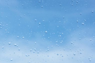 Bir bulutlu gökyüzü arka plan cam üstünde su damlaları. su doku camına