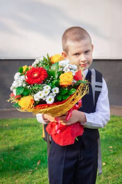 bir buket çiçek ile satırındaki ilk sınıf öğrencisi okuyor