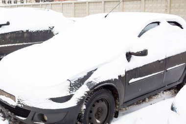 Taze karla kaplı arabalarla dolu otopark.