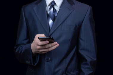 İşadamı ile smartphone üzerinde koyu mavi arka plan, telefonu elinde olan adam